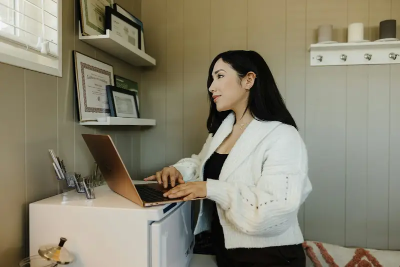 A small-business owner working on a laptop at home